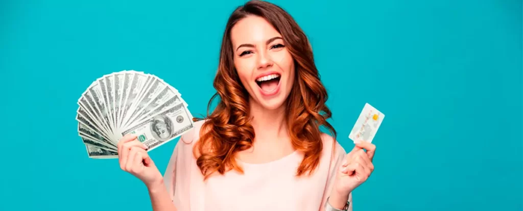 mulher feliz com dinheiro na mão e cartão de crédito na mão com fundo verde