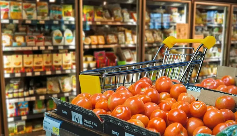 imagem de caixa de tomates no corredor do supermercado em frente ao setor de frios
