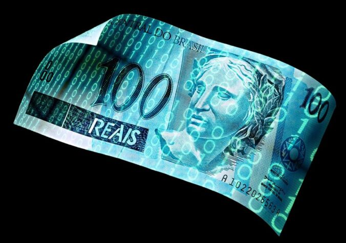 Imagem de uma nota de 100 reais sendo digitalizada