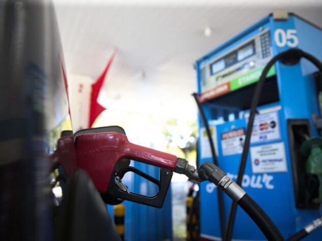 imagem de bico de bomba de abastecimento de gasolina e combustível engatado no carro