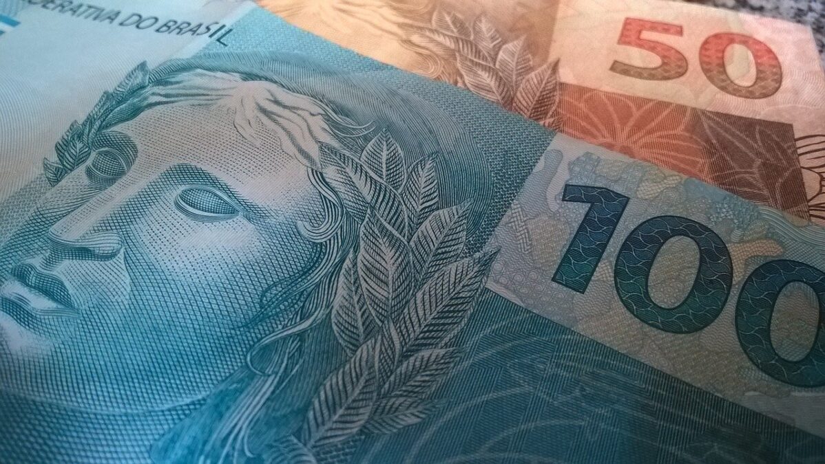 Imagem de nota de 100 reais na frente de nota de 50 reais