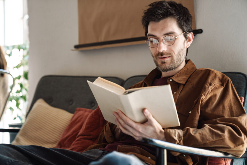 Imagem de homem sentado lendo um livro