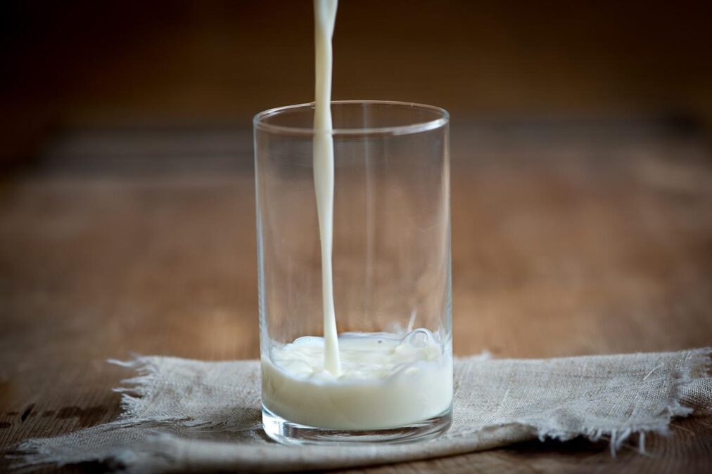 Imagem de leite de vaca sendo colocado em copo de vidro