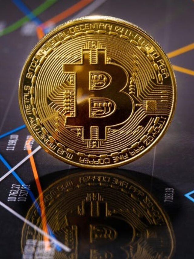 moeda bitcoin em cima de uma tela com gráficos